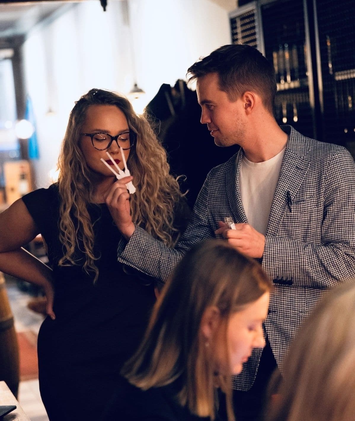 Group of people at the meetup are trying different perfumes on scent strips