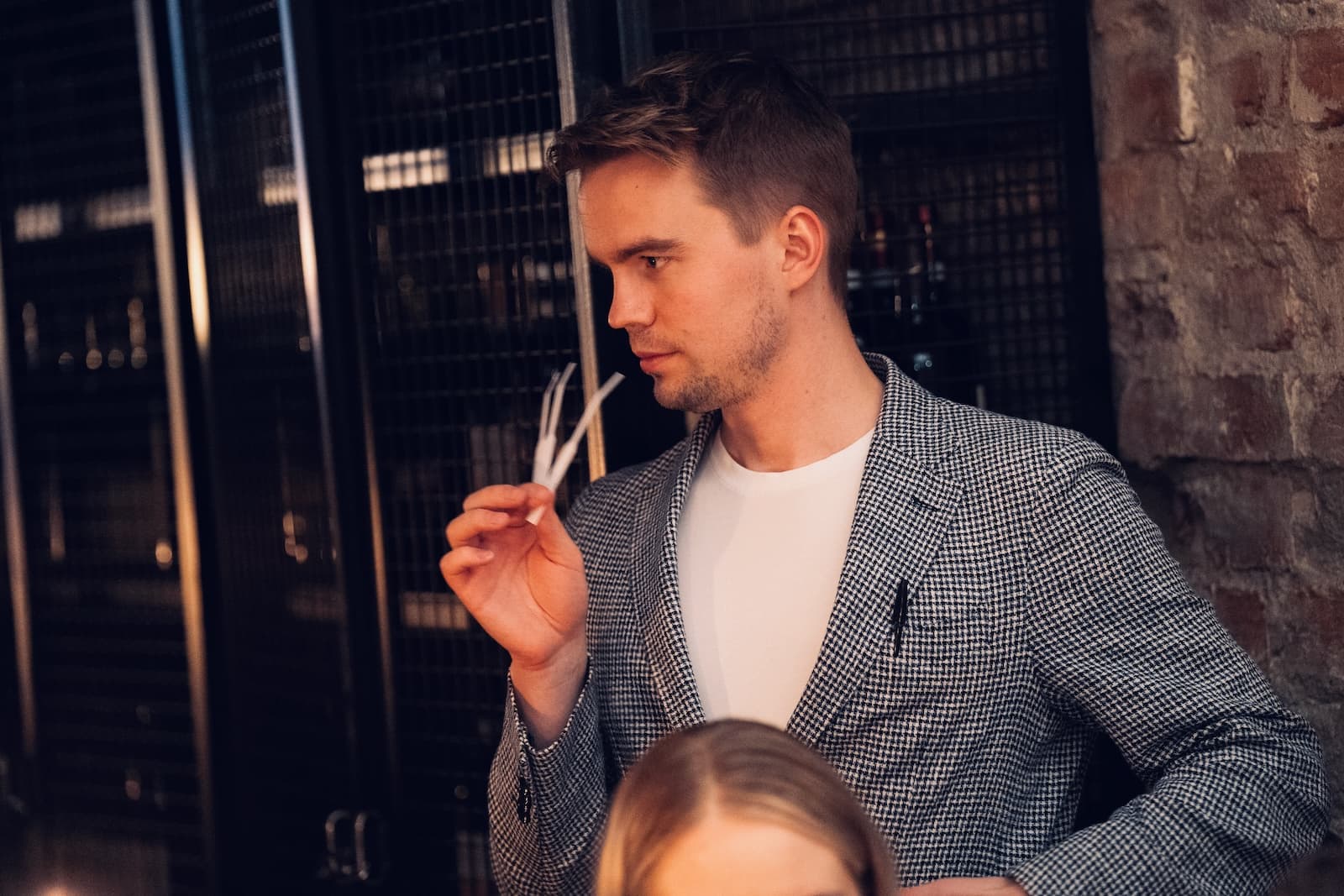 A guest in a checked jacket smelling two scent strips