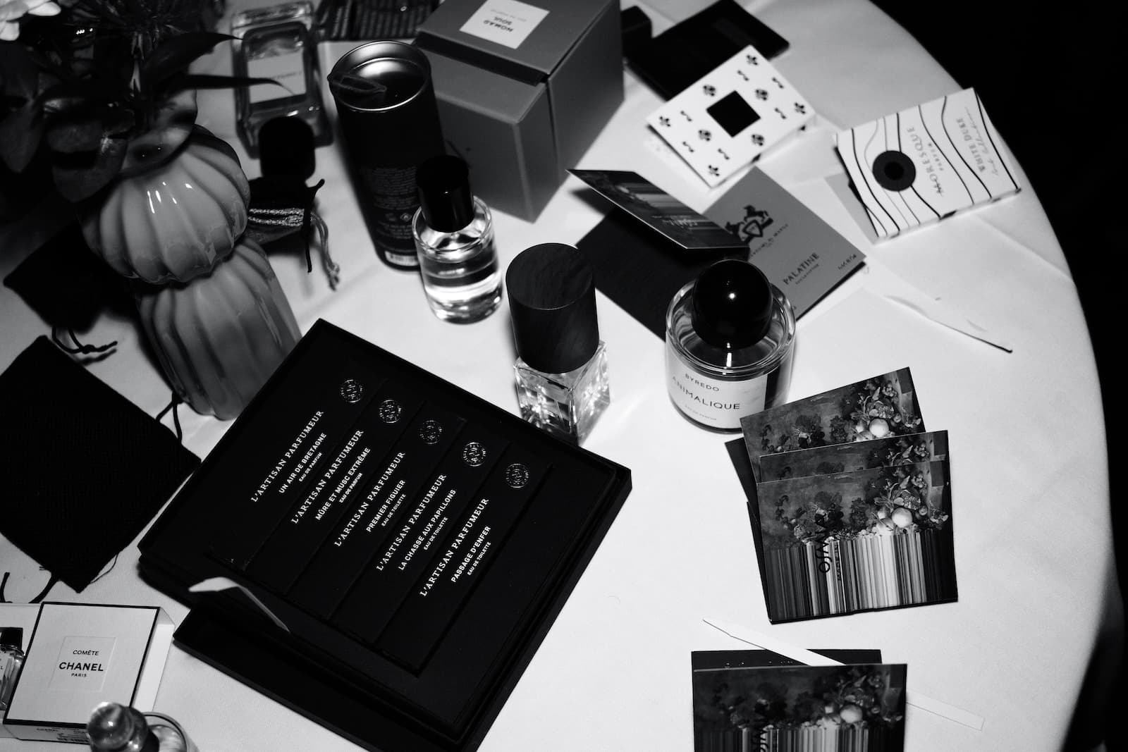 Niche perfume bottles and scent strips laid out on a table at a club evening