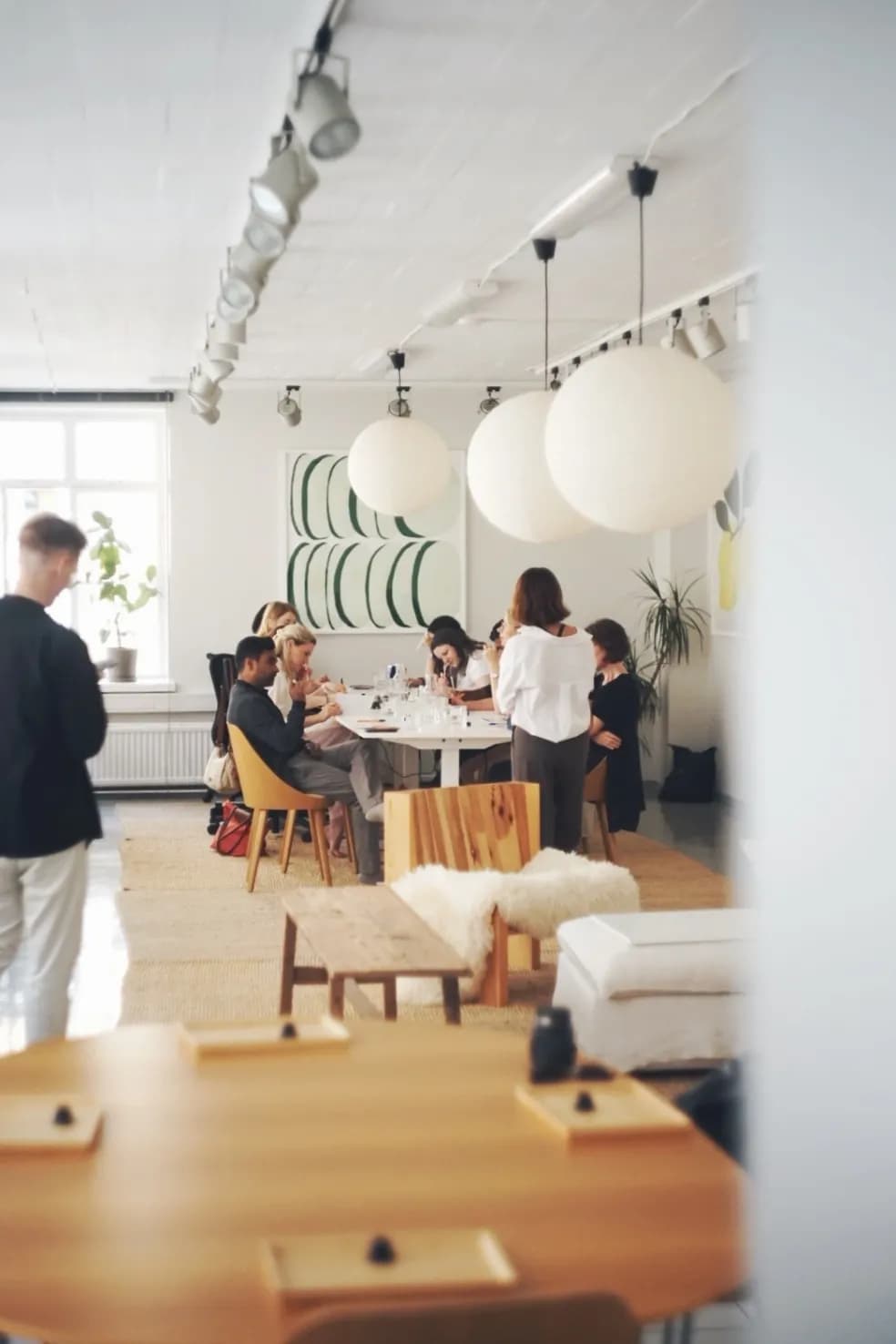 Guests working around the table at a perfume making workshop in a bright studio