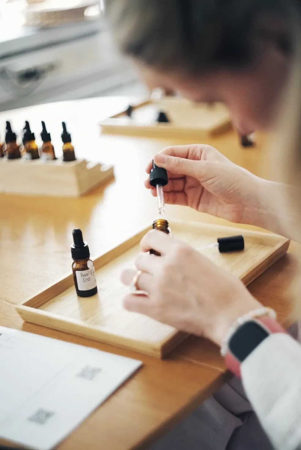 A guest adding a material with a pipette while blending a fragrance at a workshop
