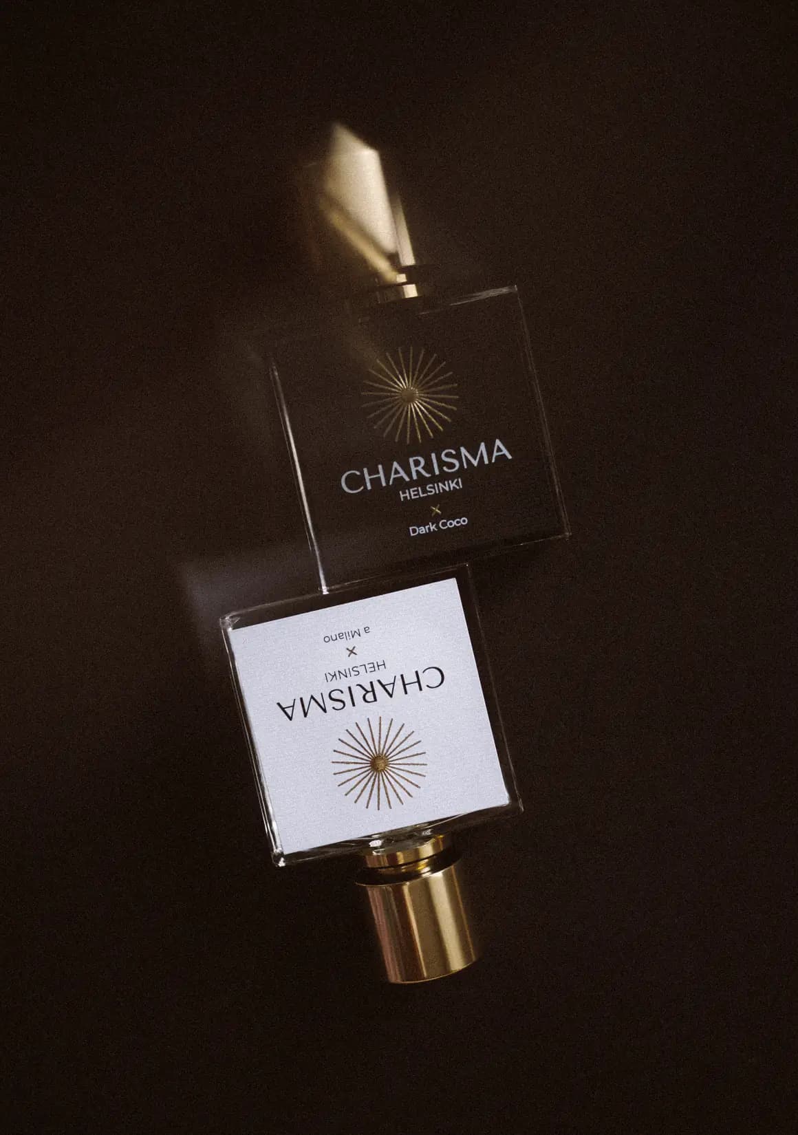 Two Charisma Helsinki bottles on a dark surface, one mirroring the other